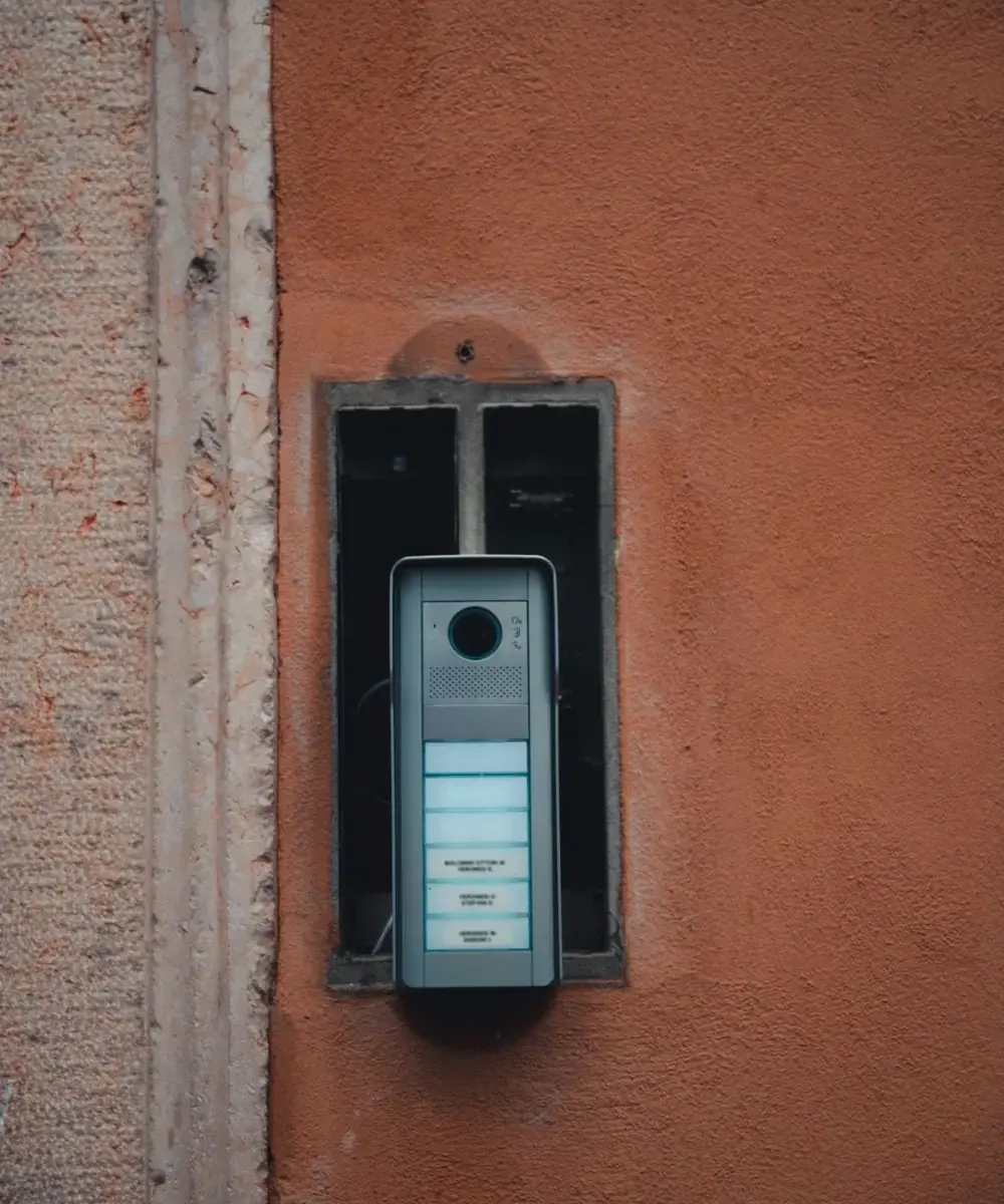 Door station with camera and call buttons on an outside wall